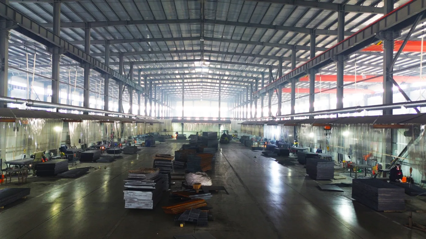 Wide view of the manual welding workshop with steel grating panels and welding stations