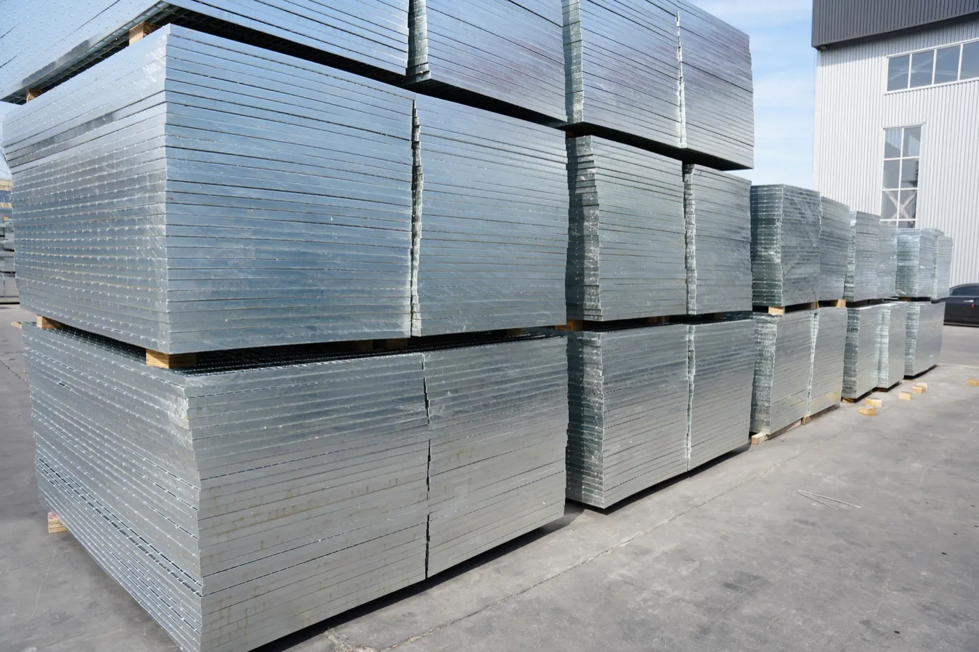 Stacks of finished galvanized steel grating panels in the factory yard