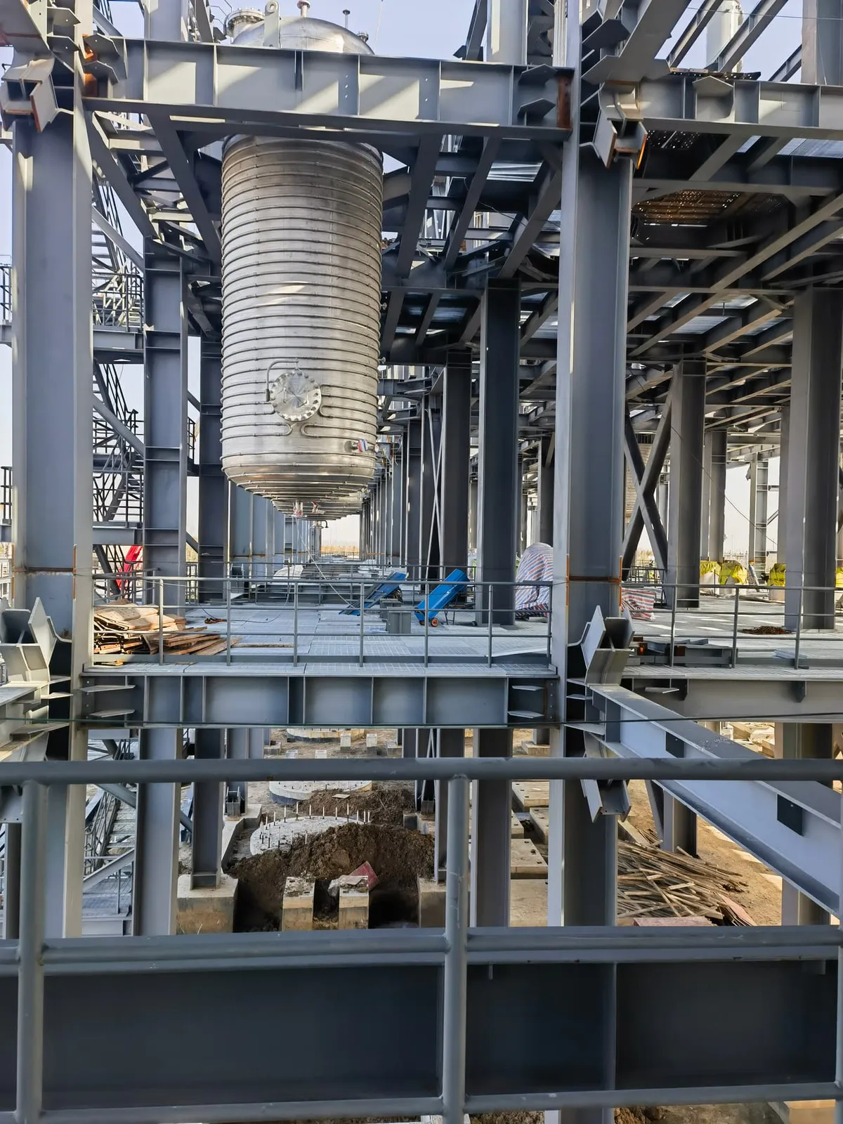 Elevated steel grating operating floor around process vessels in a chemical plant
