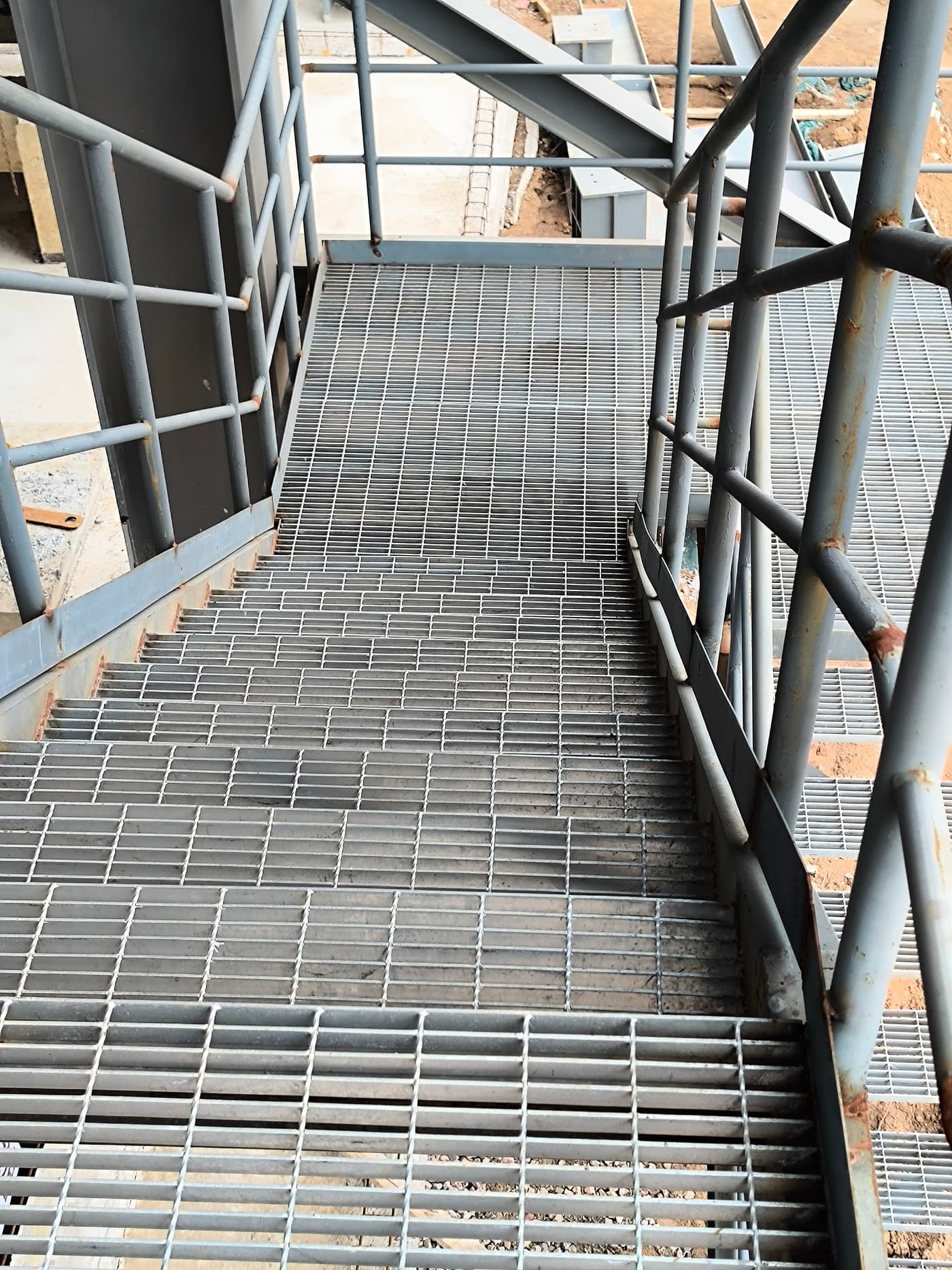 Curved grating walkway and guardrail around process equipment