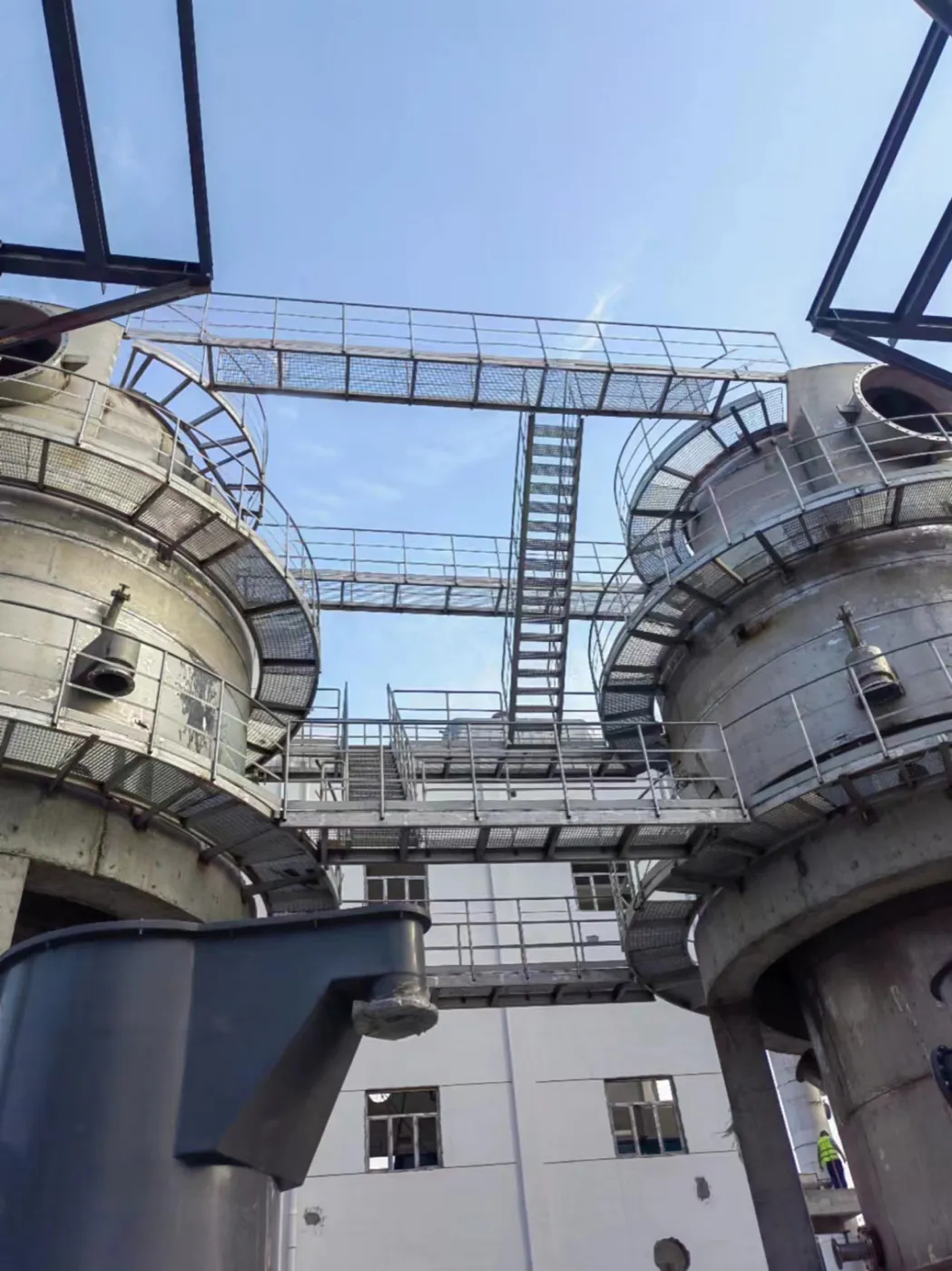 Circular steel grating maintenance platform around a chemical process tower