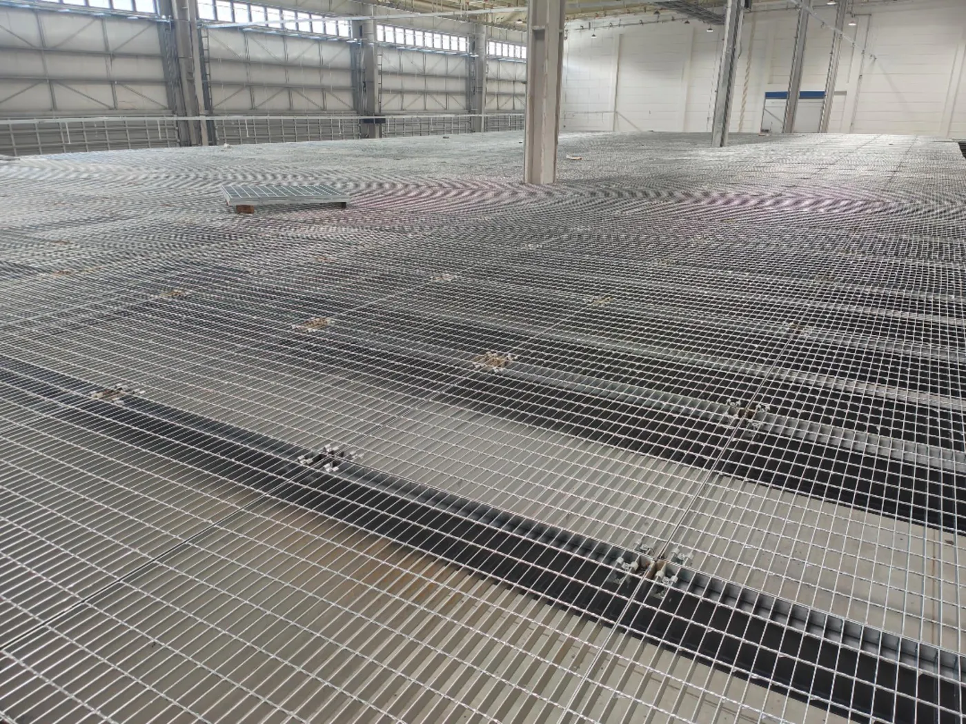 Large-area steel grating floor installation in a factory