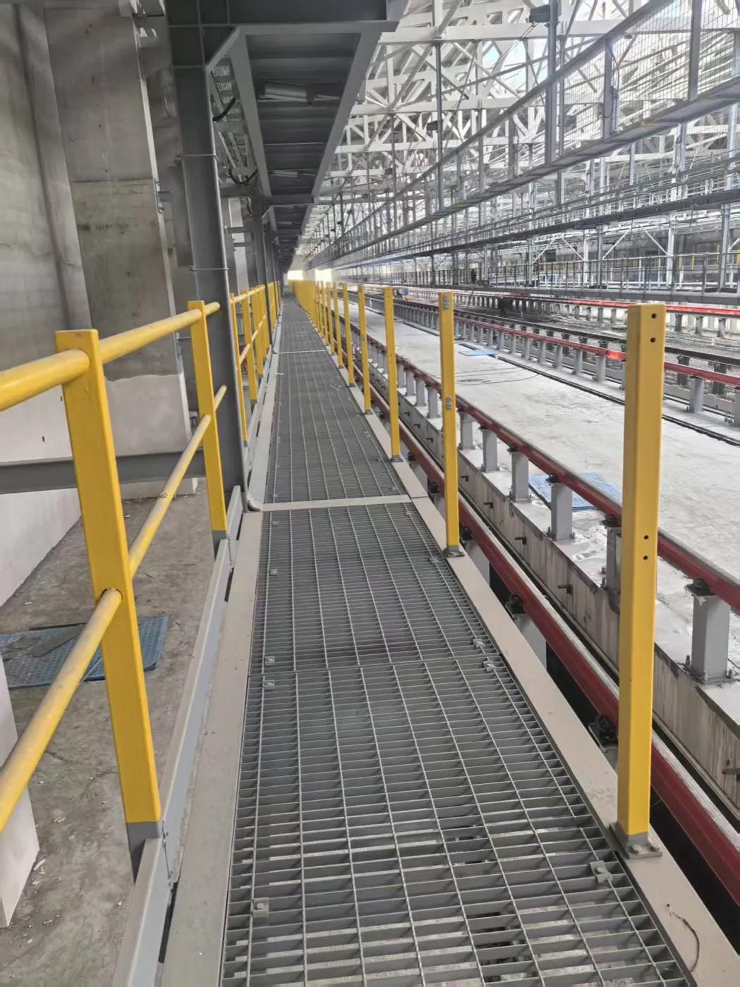 Galvanized grating maintenance walkway beside pipe-rack equipment