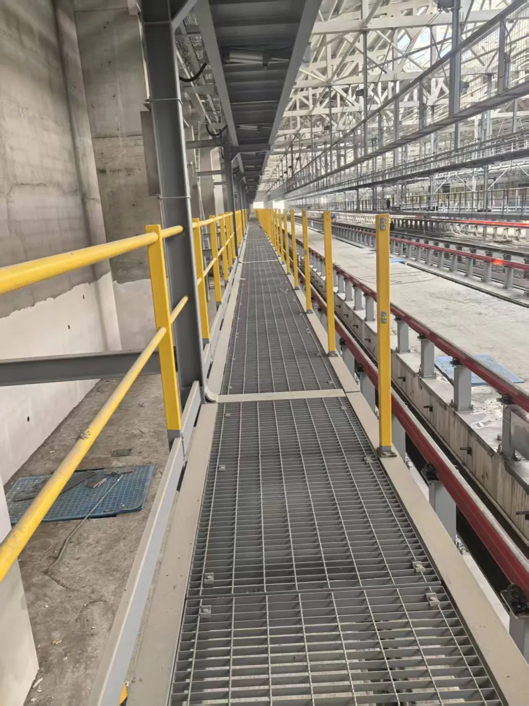 Long steel grating access route through an industrial pipe rack