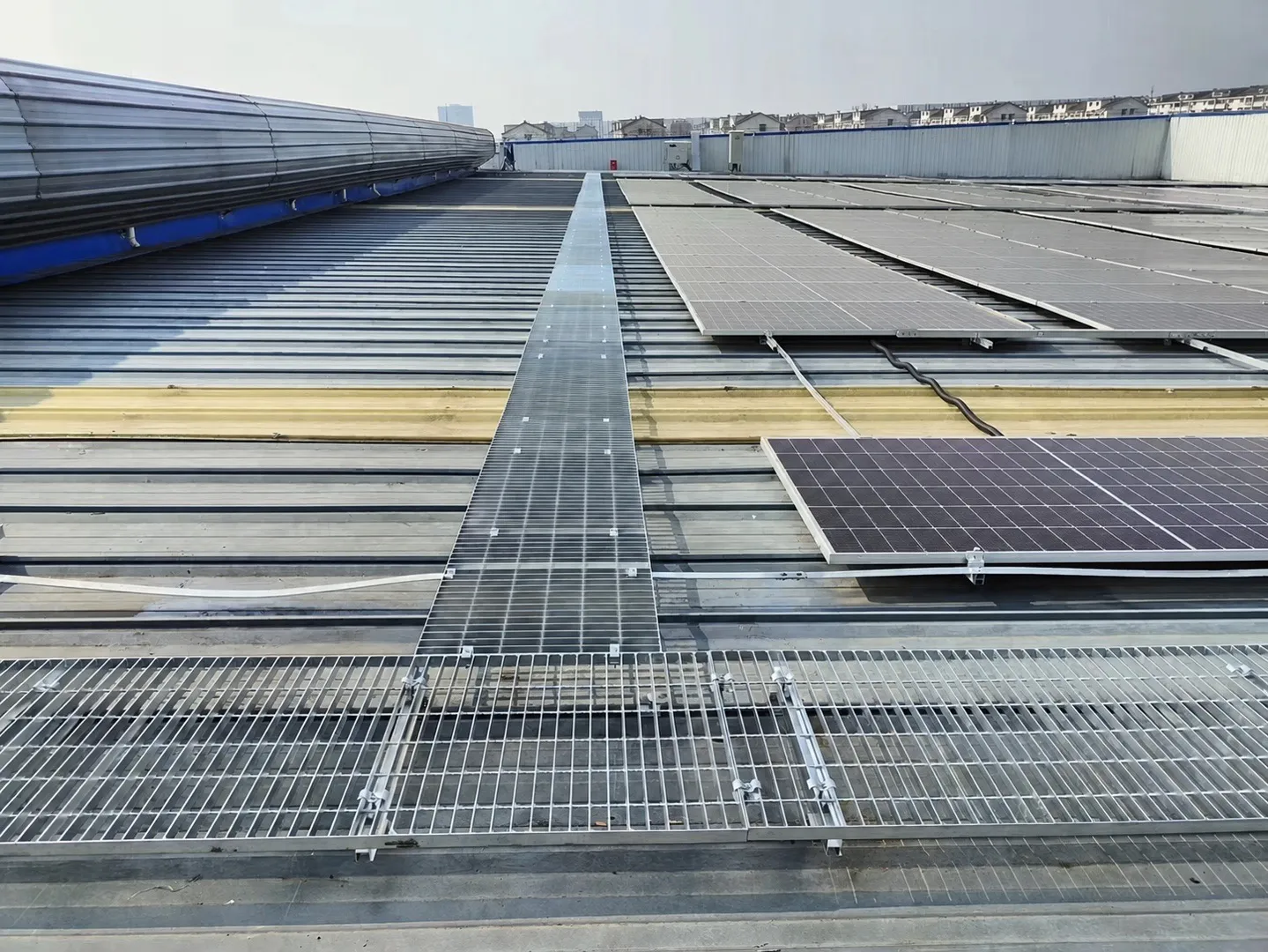 Galvanized steel grating maintenance walkway between rooftop solar panels