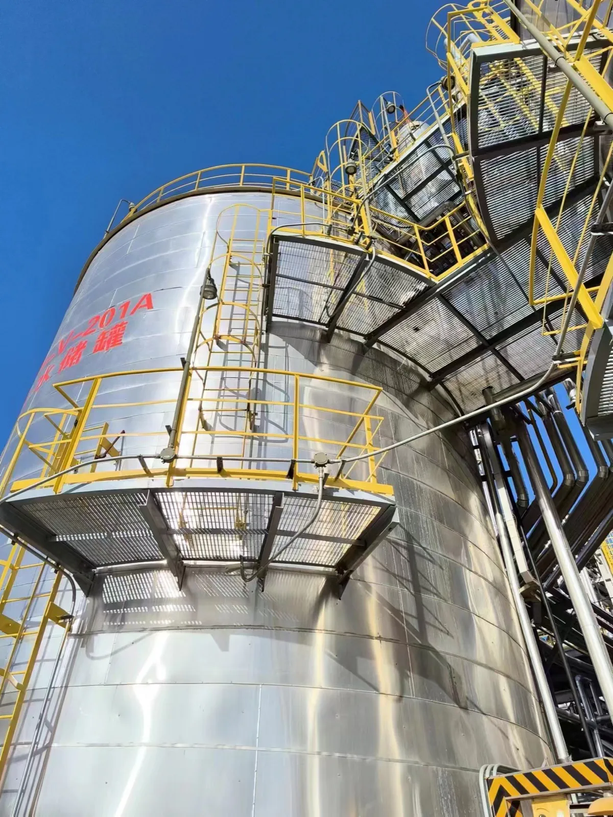 Steel grating maintenance platform serving an industrial tank farm