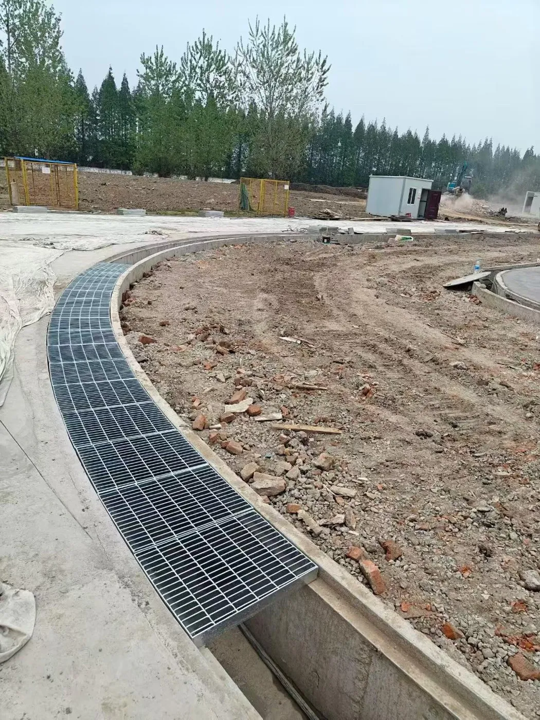 Curved steel grating drainage channel in a landscaped area