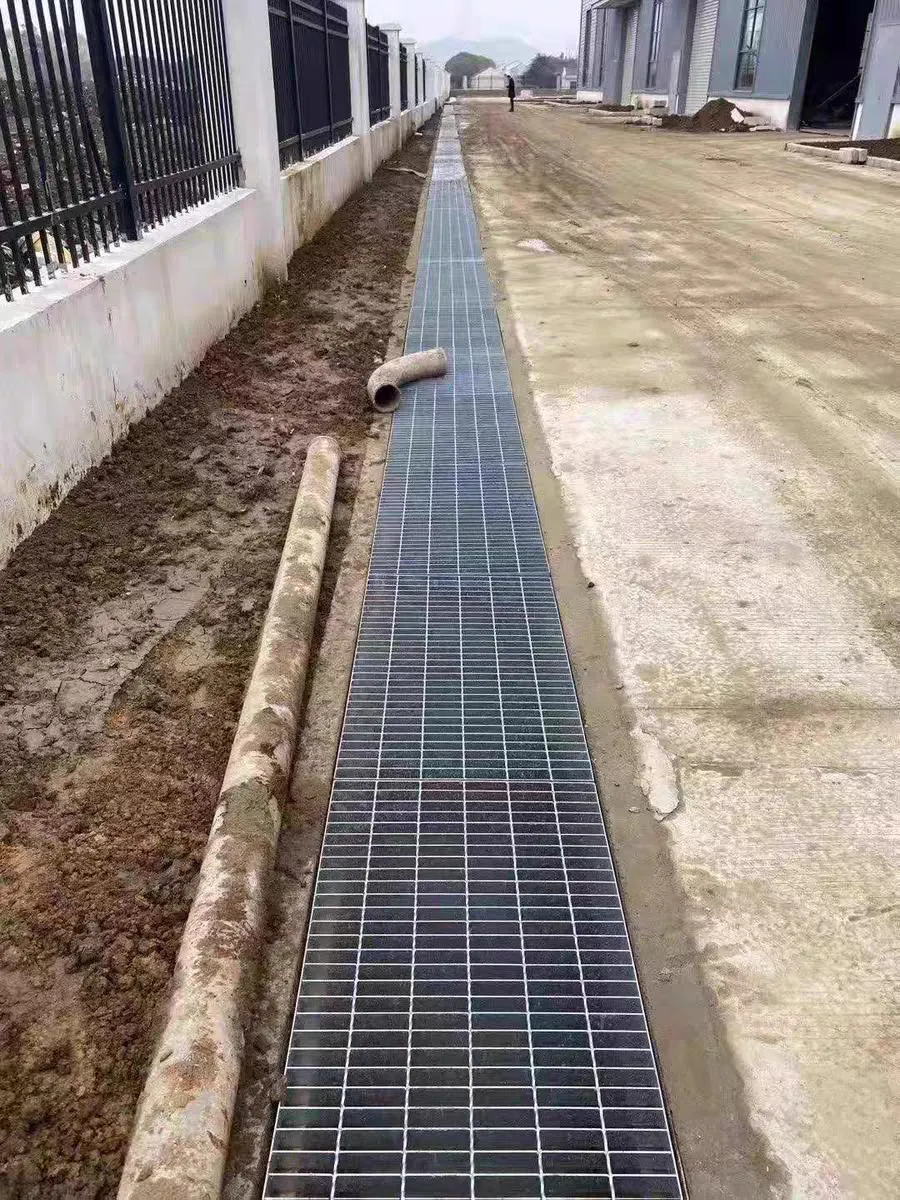 Long run of galvanized drainage grating across an industrial site
