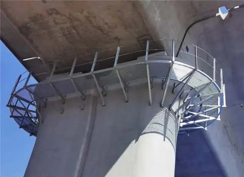 Circular steel grating access walkway being installed around a bridge pier