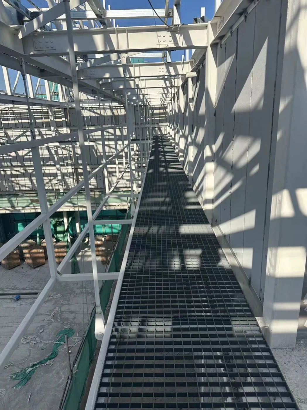 Elevated steel grating maintenance walkway inside an industrial plant