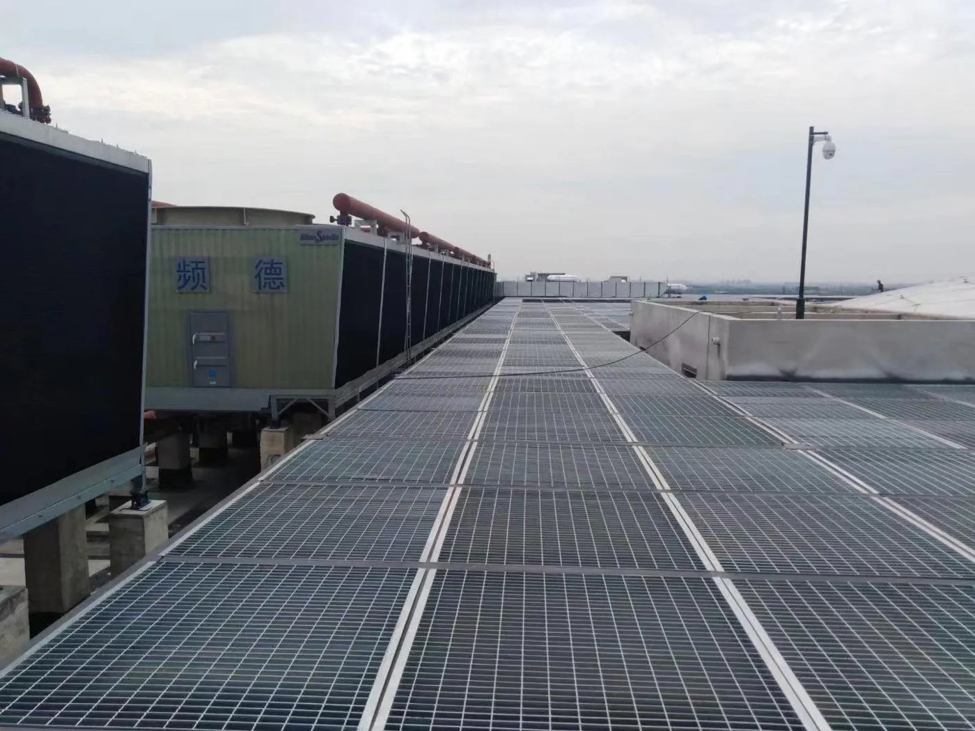 Long steel grating access walkway across an industrial roof