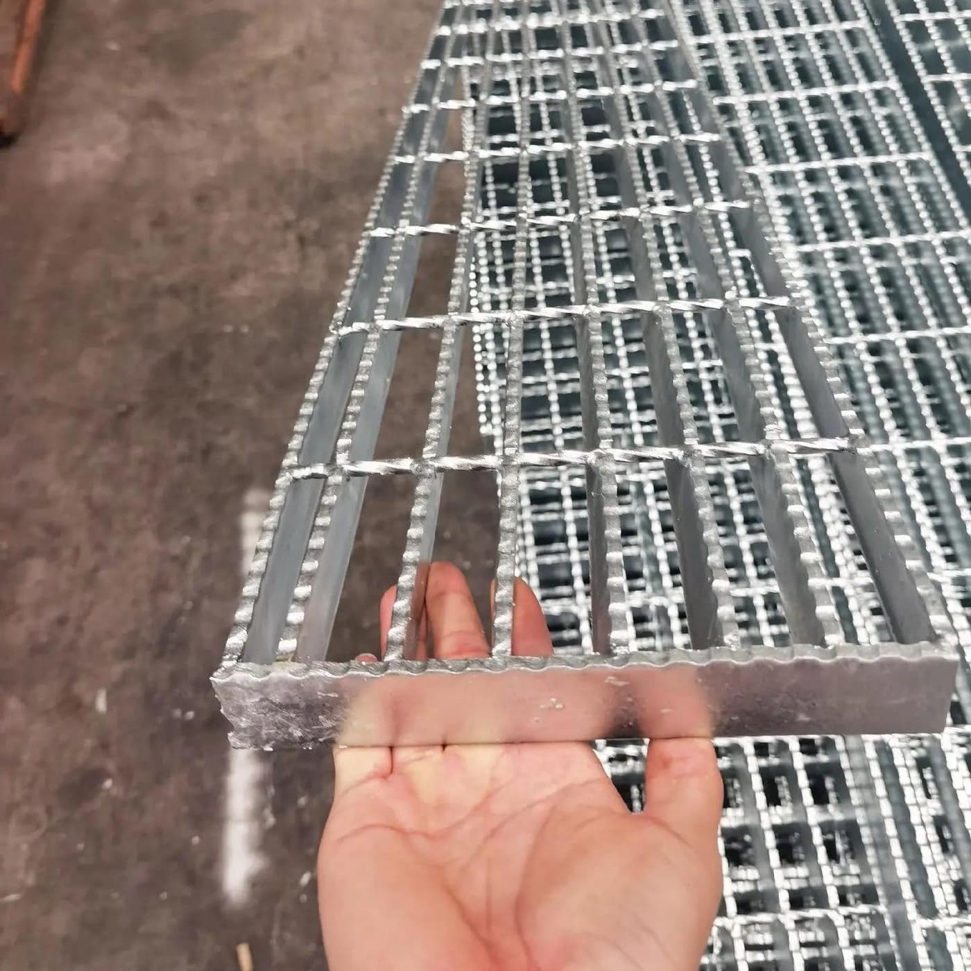 Hand-held corrosion-resistant grating sample showing its bearing-bar profile