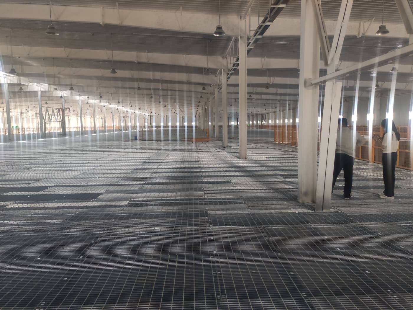 Wide warehouse platform covered with repeated open grating panels