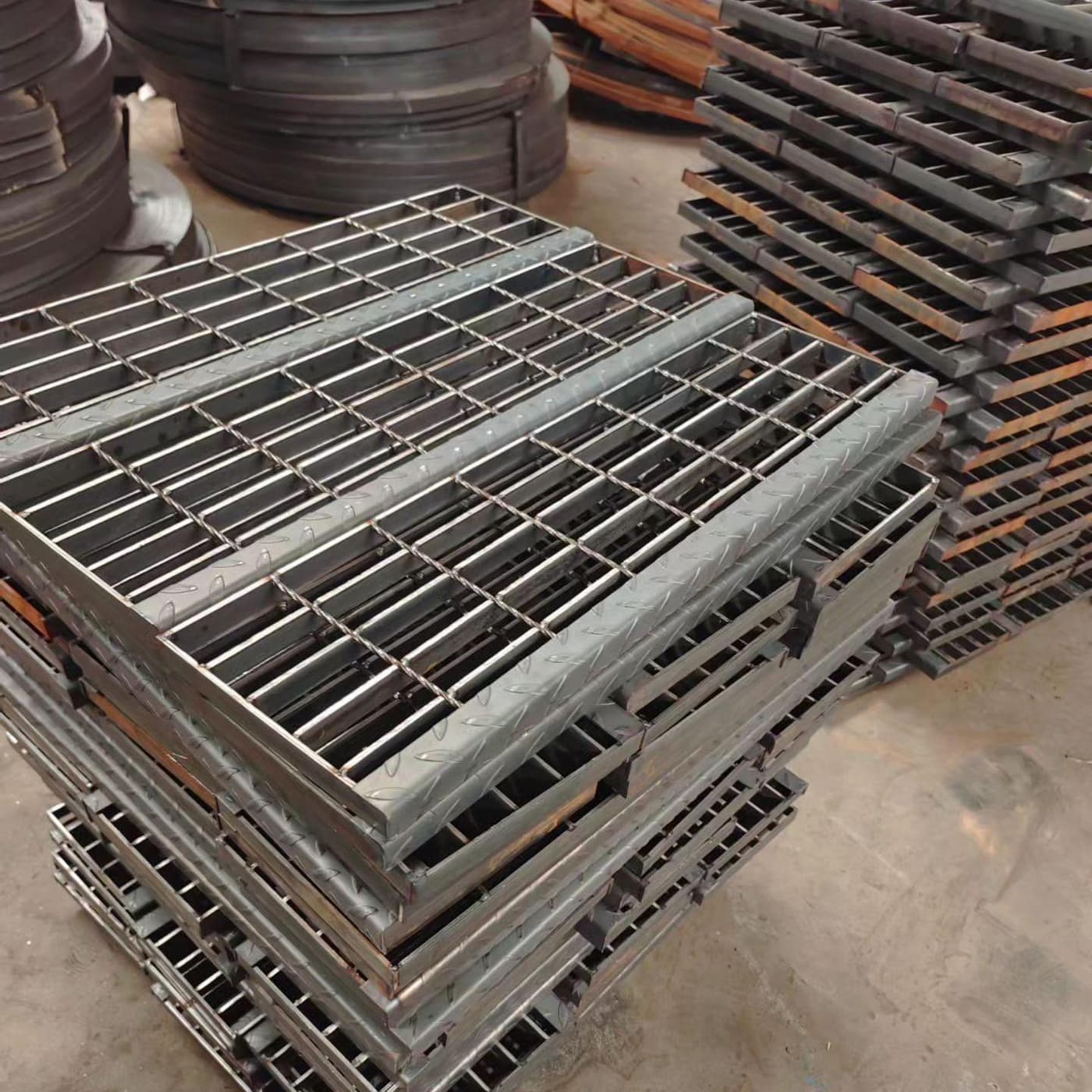 Stack of fabricated compound grating frames and panels in a workshop