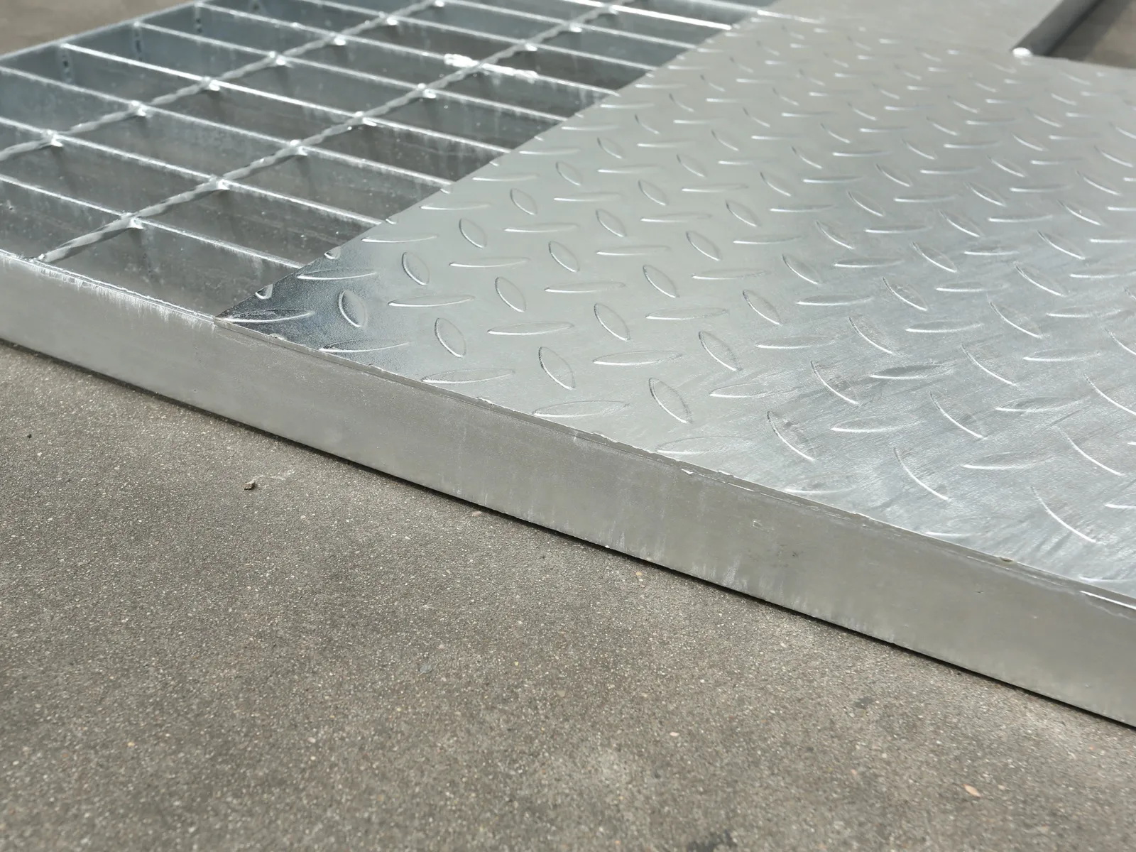 Galvanized compound steel grating showing open bar grating beside a checker plate surface