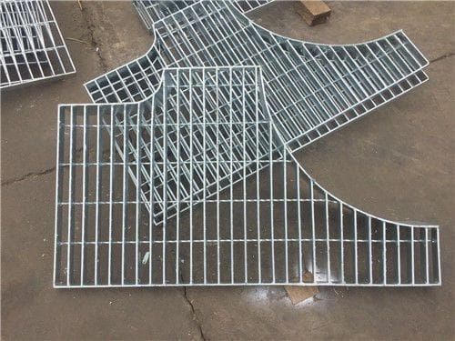 Group of galvanized non-rectangular grating panels with curved cut edges