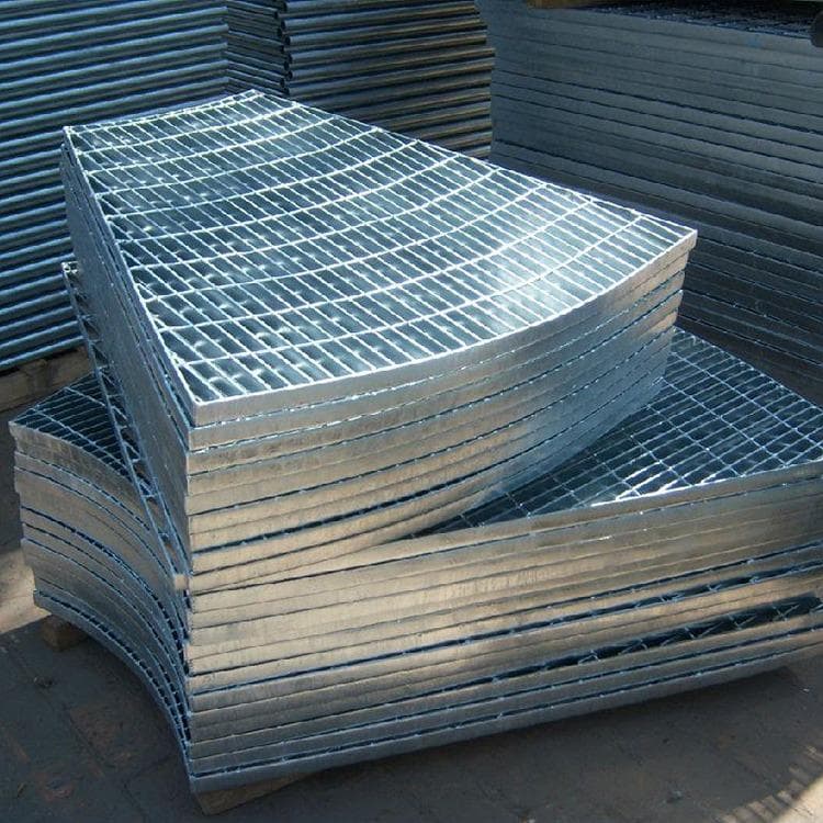 Stack of curved galvanized grating panels ready for project numbering