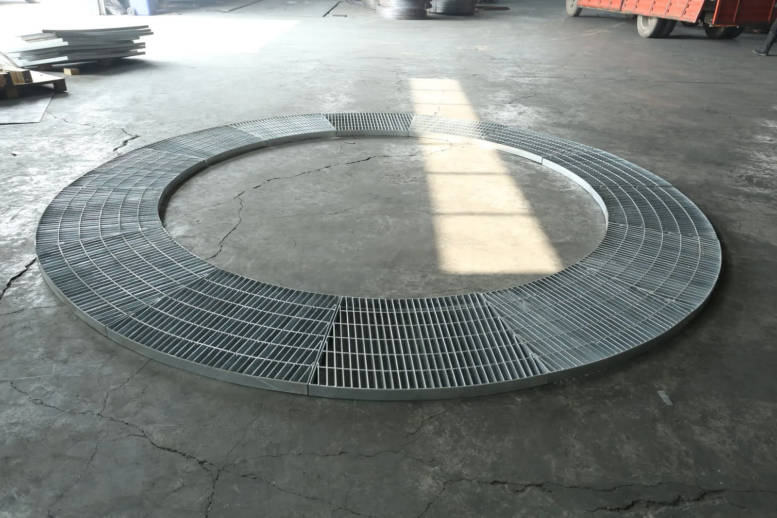 Workshop trial assembly of fan-shaped steel grating panels forming a complete annular ring
