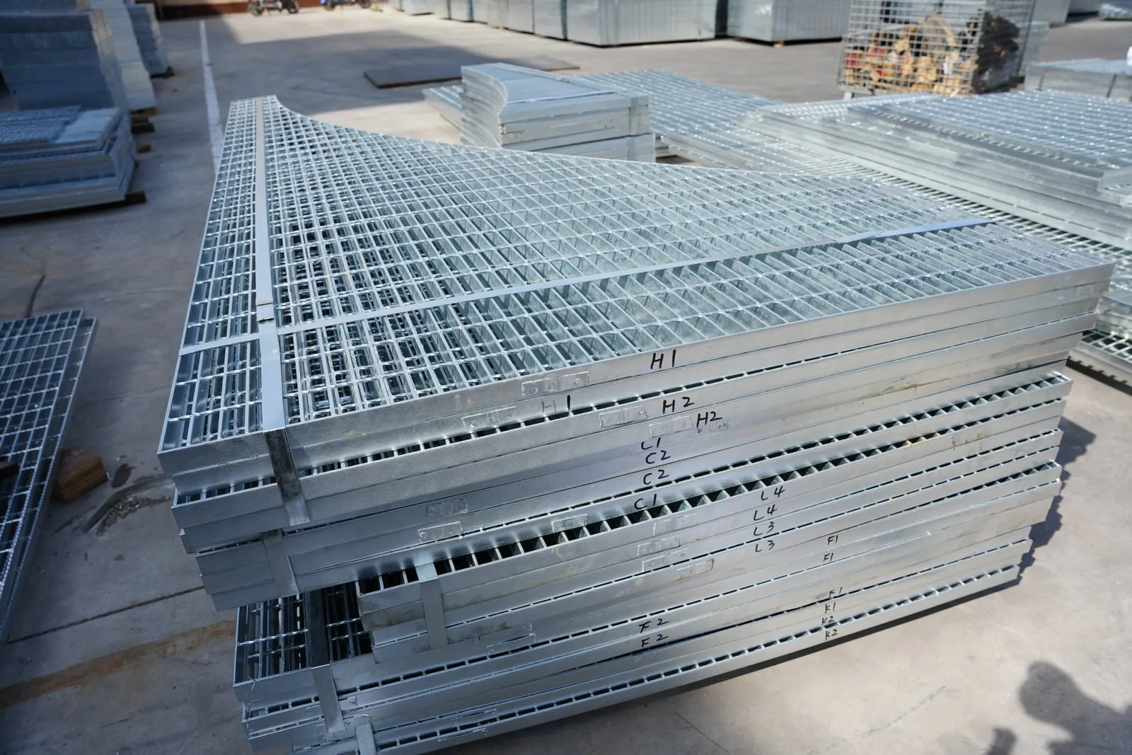 Stacked notched steel grating panels marked for layout identification