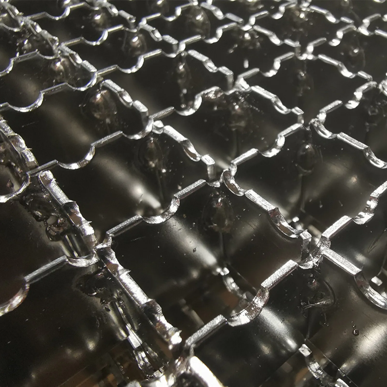 Close-up of reflective serrated bearing-bar tops and welded cross bars