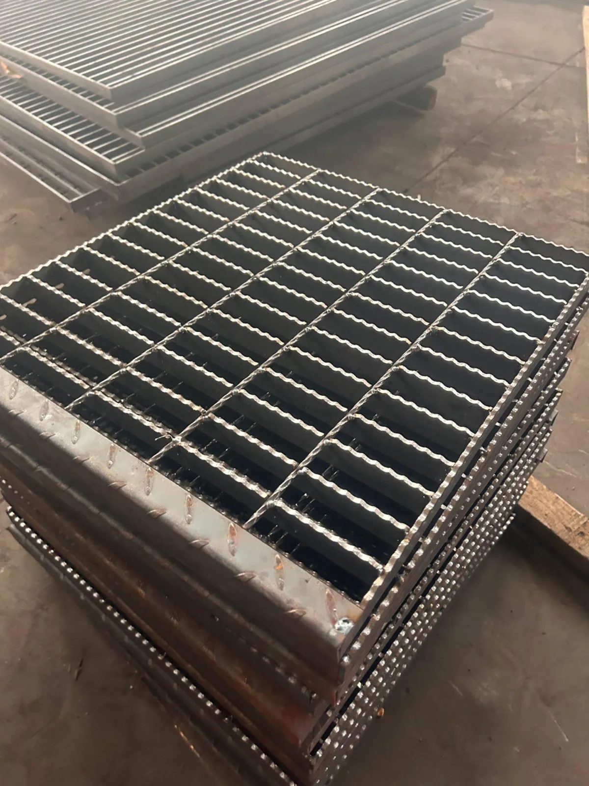 Stacked deep serrated steel grating panels with banded perimeters