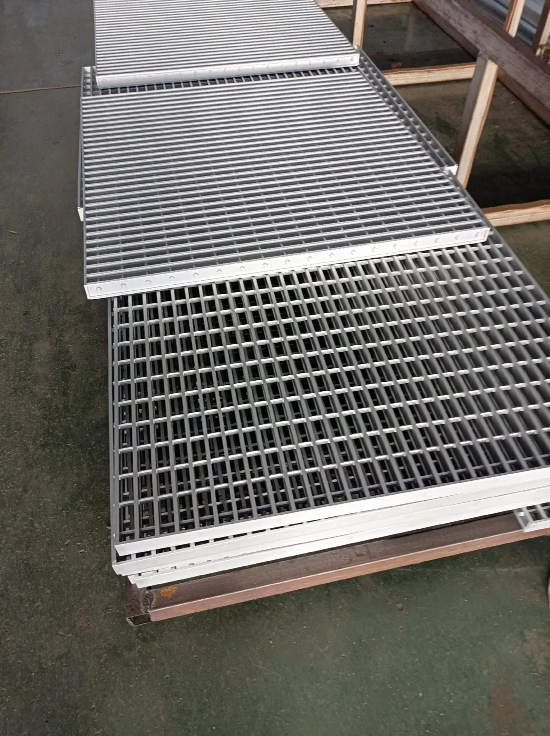Fabricated aluminum grating panels staged on workshop supports before packing