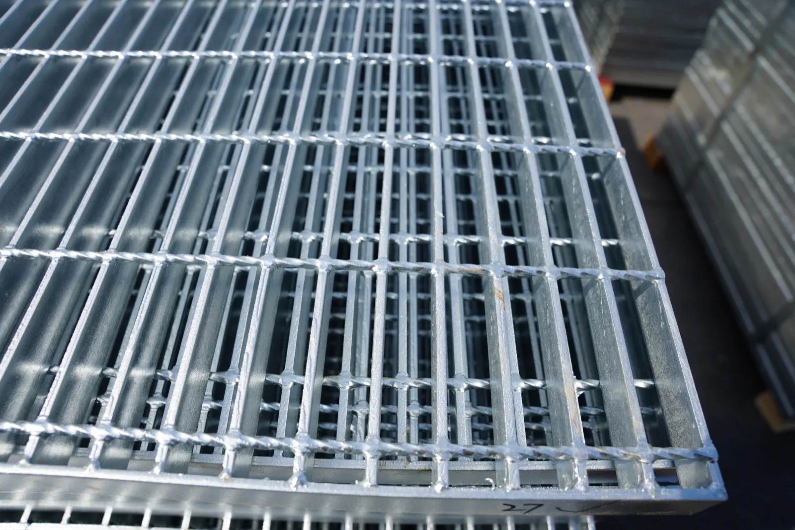 Close-up of stacked hot-dip galvanized welded steel grating panels
