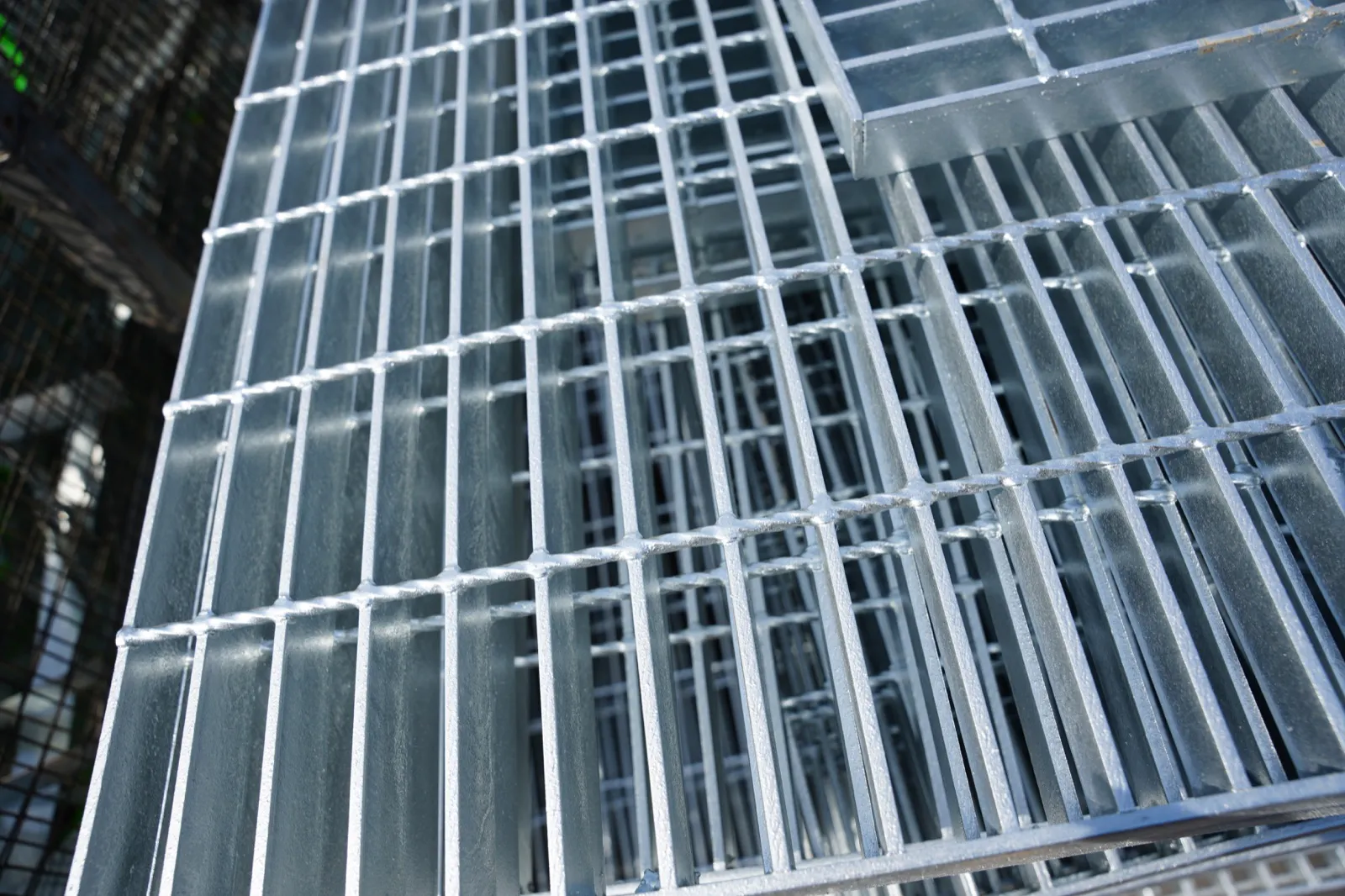 Overlapping welded steel grating panels showing bearing bars and cross bars