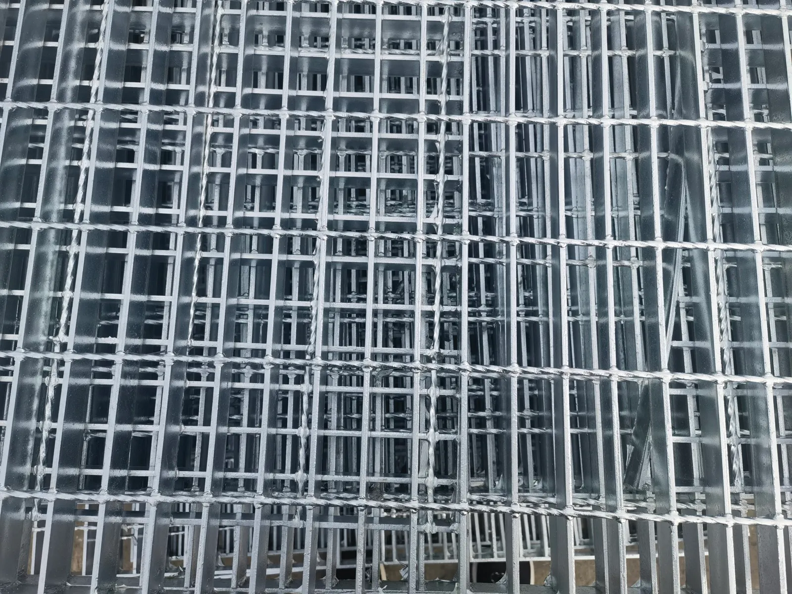 Stacked welded steel grating panels showing regular rectangular openings
