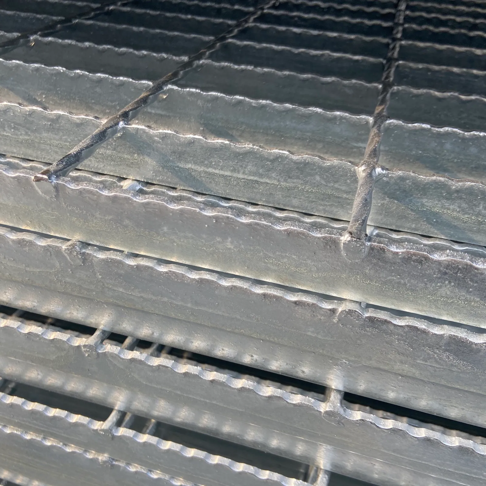 Serrated welded steel grating bearing bars with a toothed walking surface