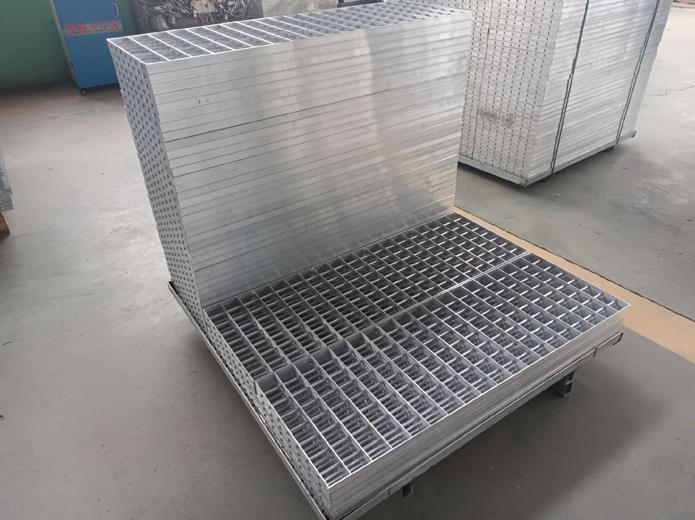 Stacked finished aluminum grating panels in a workshop