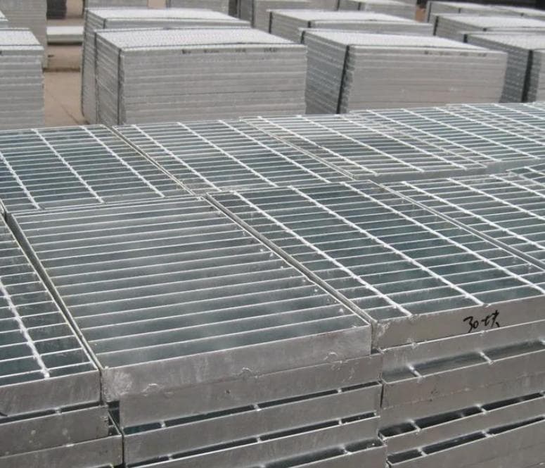 Stacks of relatively thin galvanized grating panels prepared in the workshop