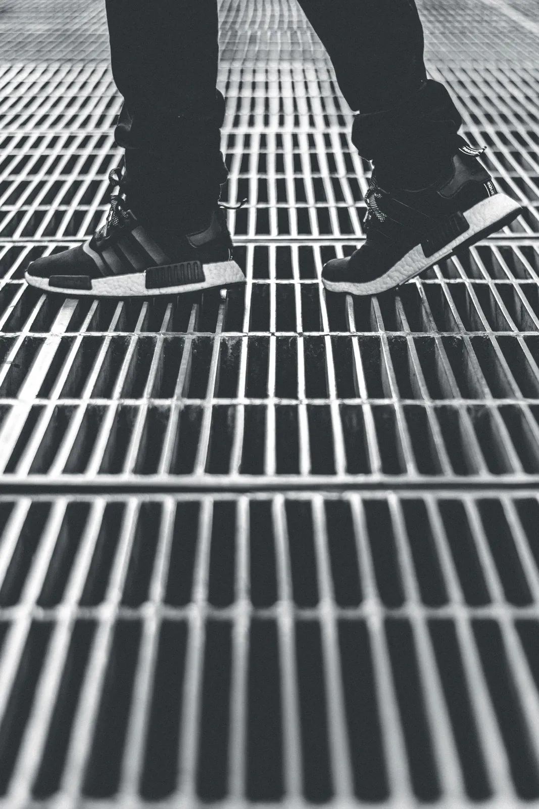 Pedestrian standing on an open steel grating access surface