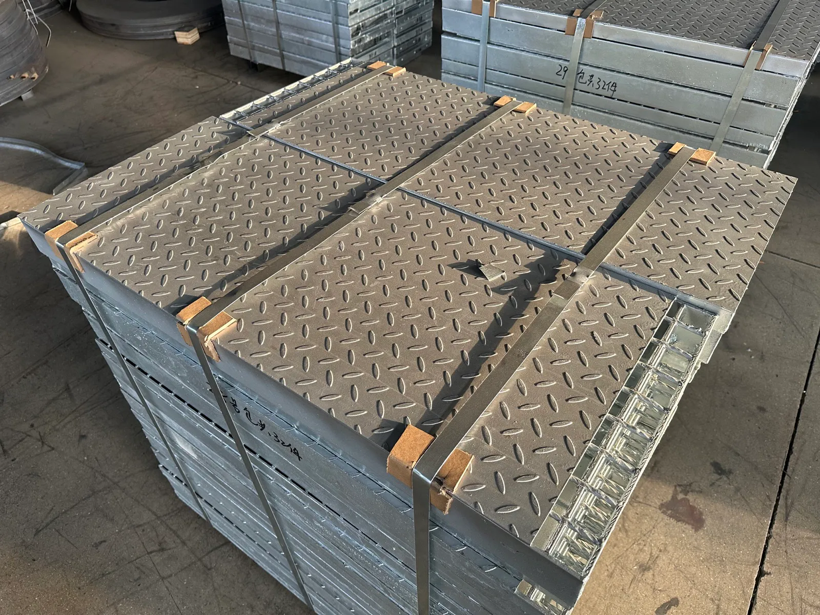 Compound steel grating panels with checker plate surfaces stacked and secured by steel straps