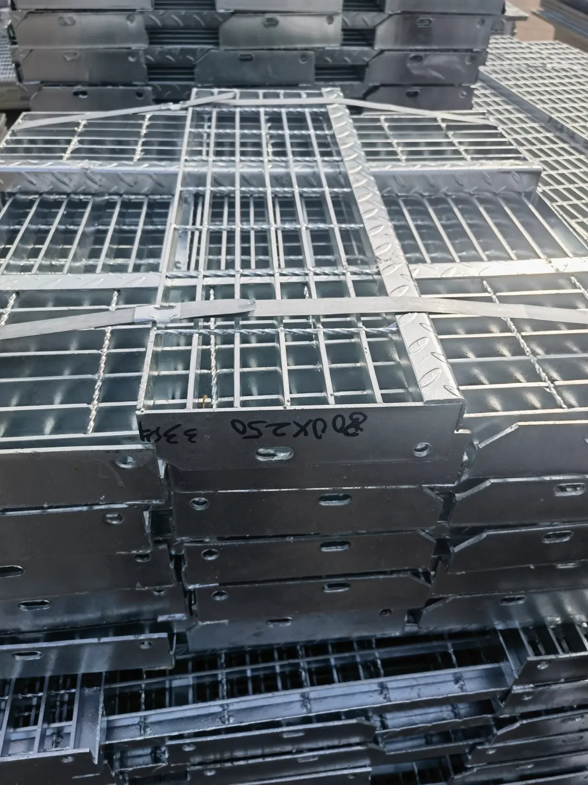 Galvanized stair tread grating bundles stacked in the workshop before packing
