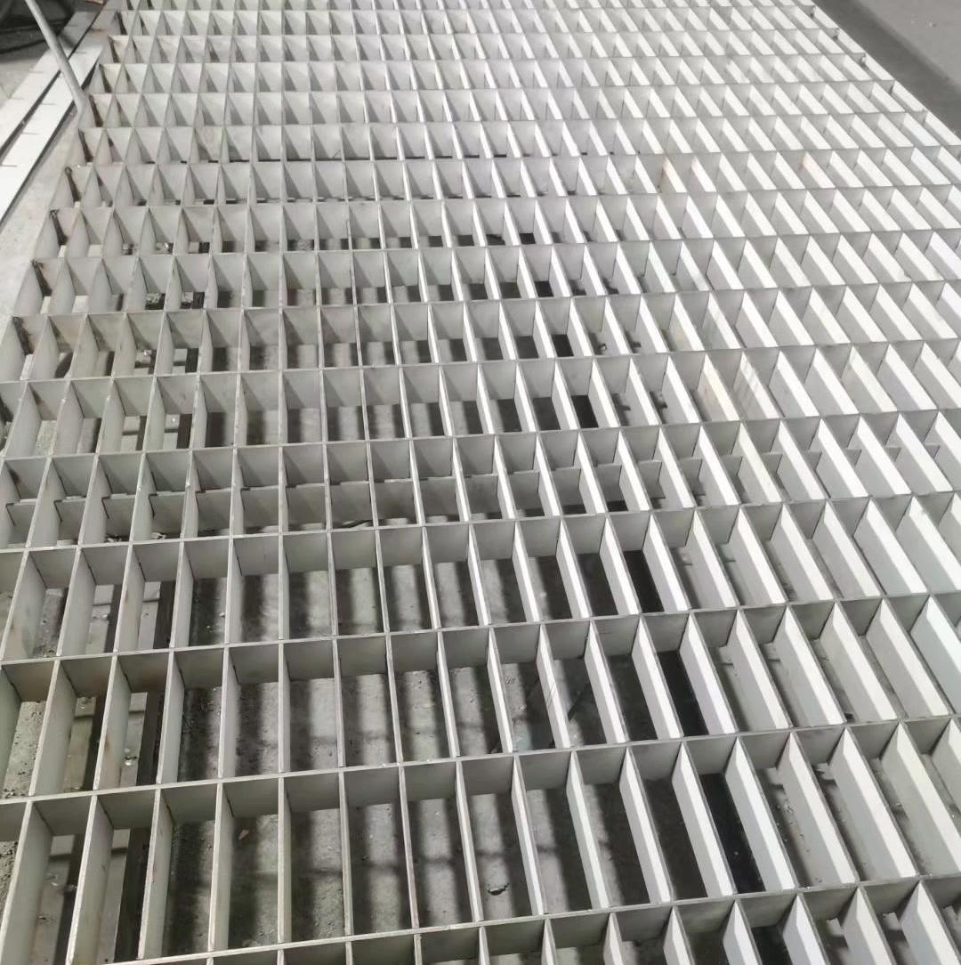 Close view of flat cross bars seated through slotted bearing bars in press-locked grating