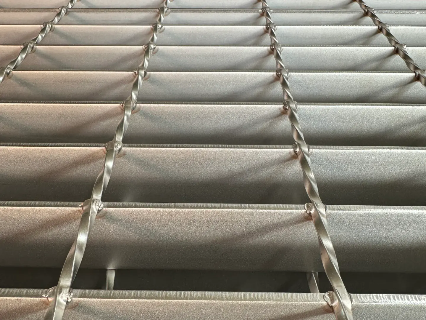 Close-up of welded stainless steel bar grating with twisted cross bars and flat bearing bars