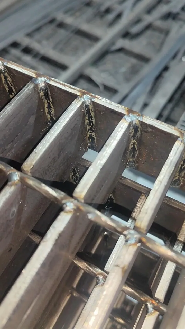 Close-up of welded steel grating bearing bars and cross-bar joints