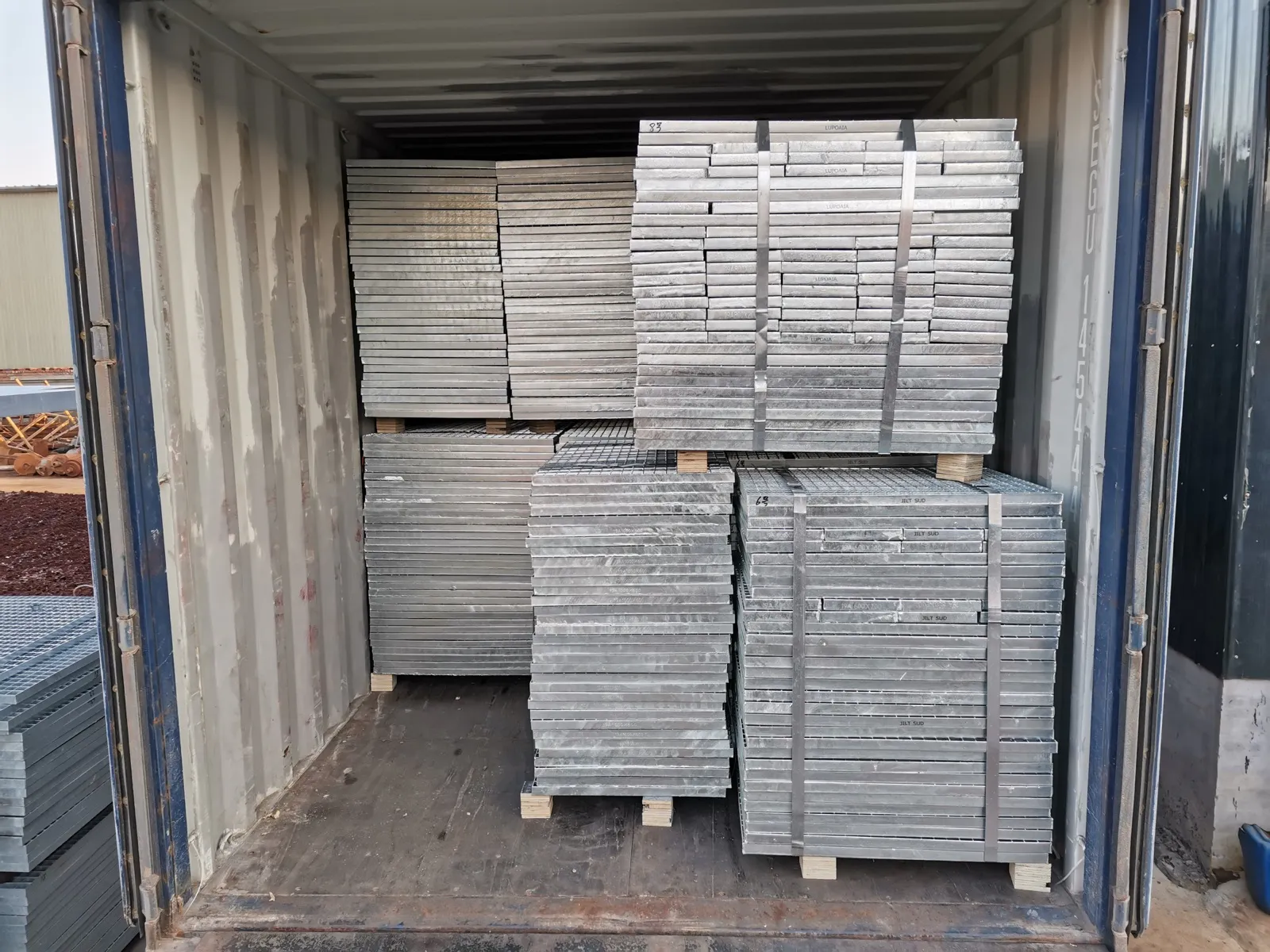 Strapped steel grating bundles arranged inside a 20 foot shipping container