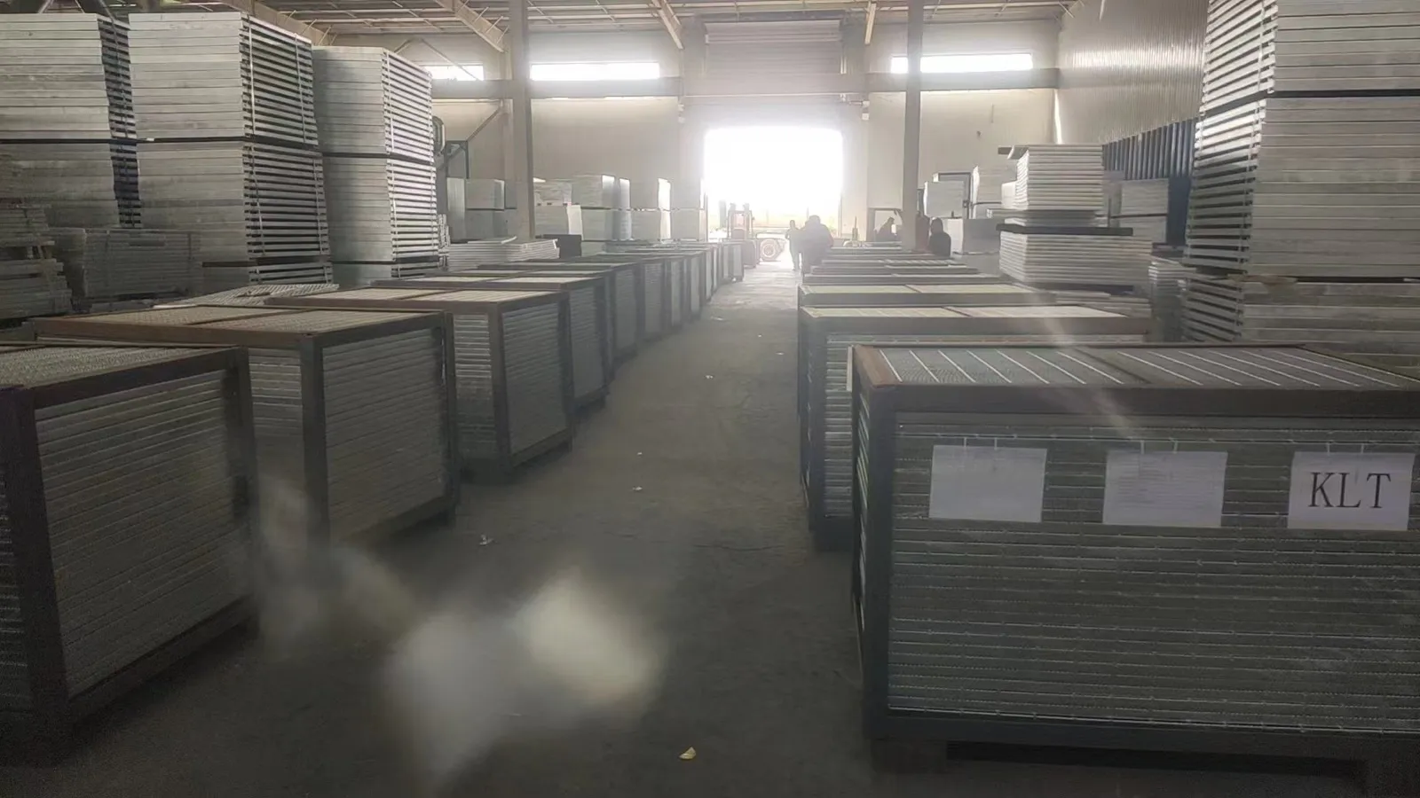 Rows of steel-frame packed grating bundles staged inside the workshop