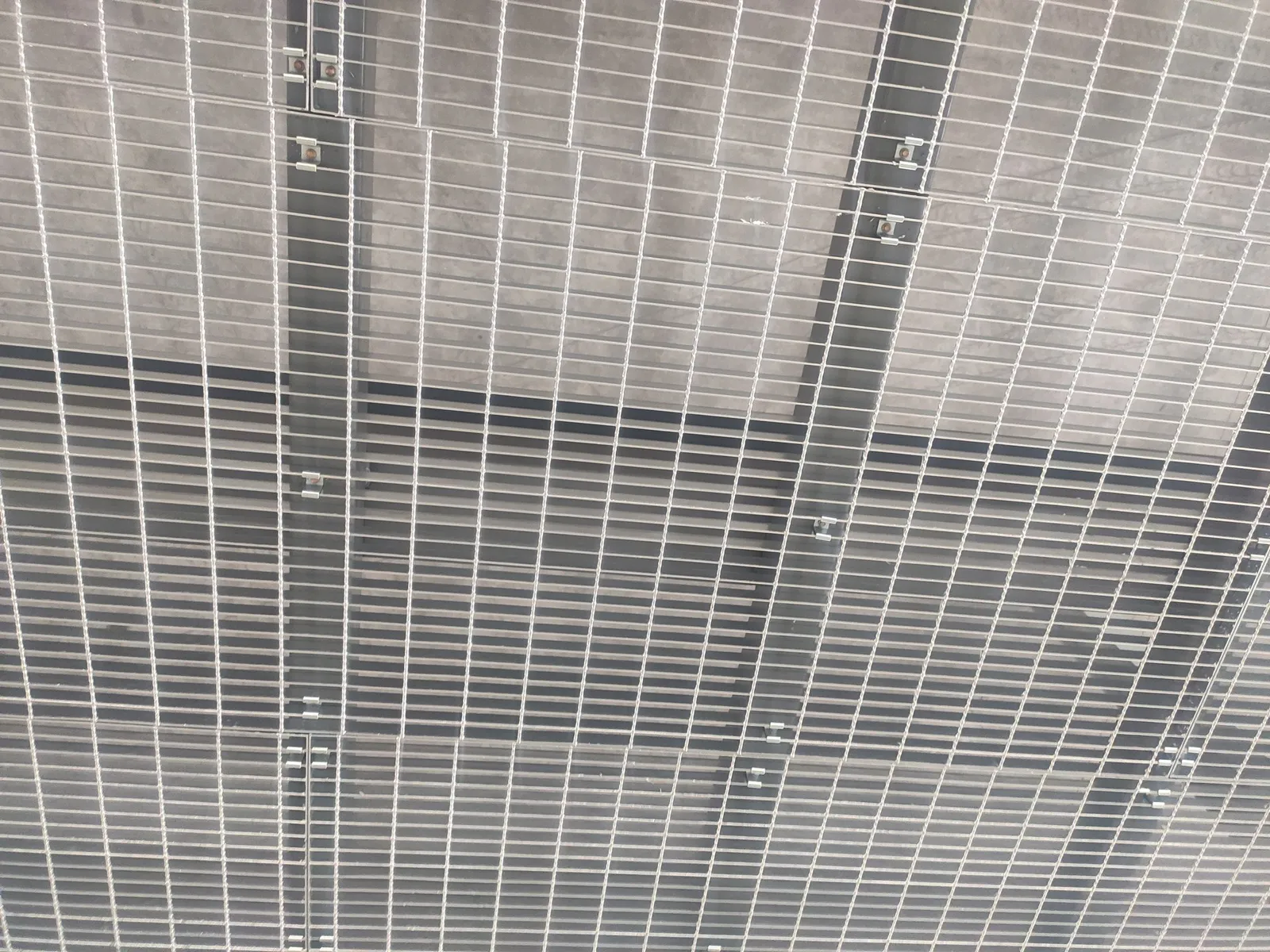 Close view of steel grating panel joints and fixings on the logistics platform