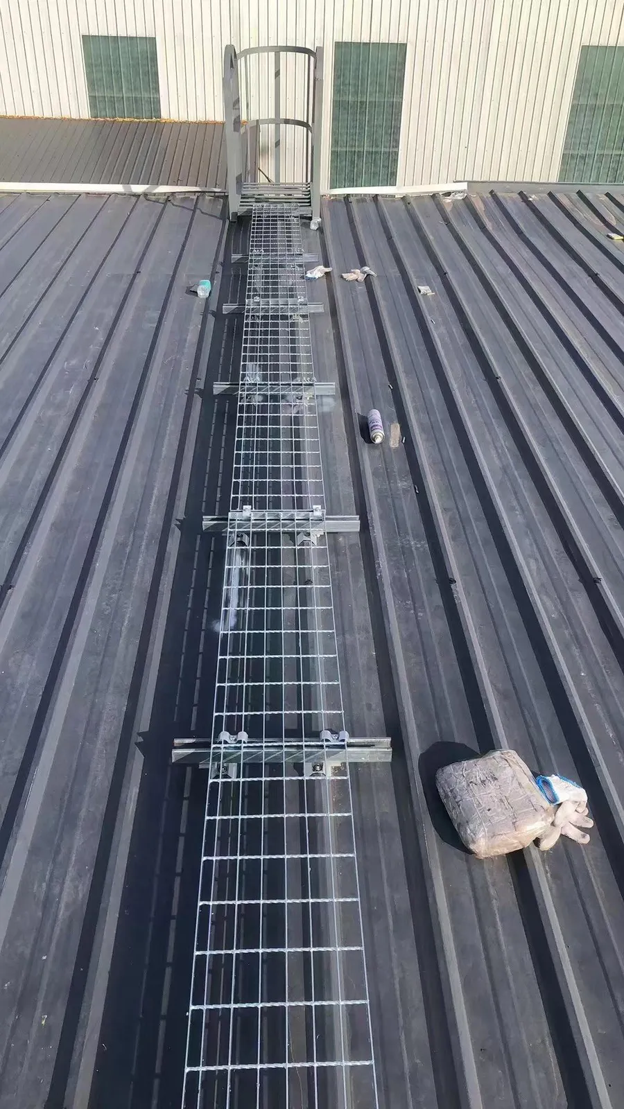 Rooftop steel grating walkway connected to an access ladder