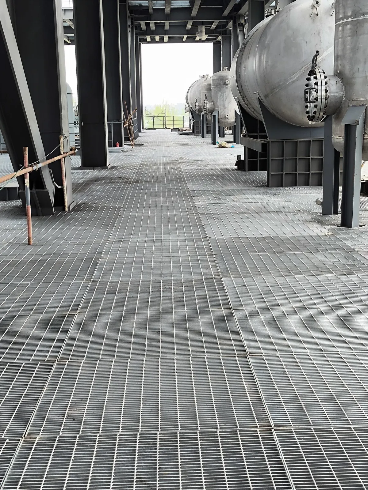 Steel grating operating floor fitted around process equipment