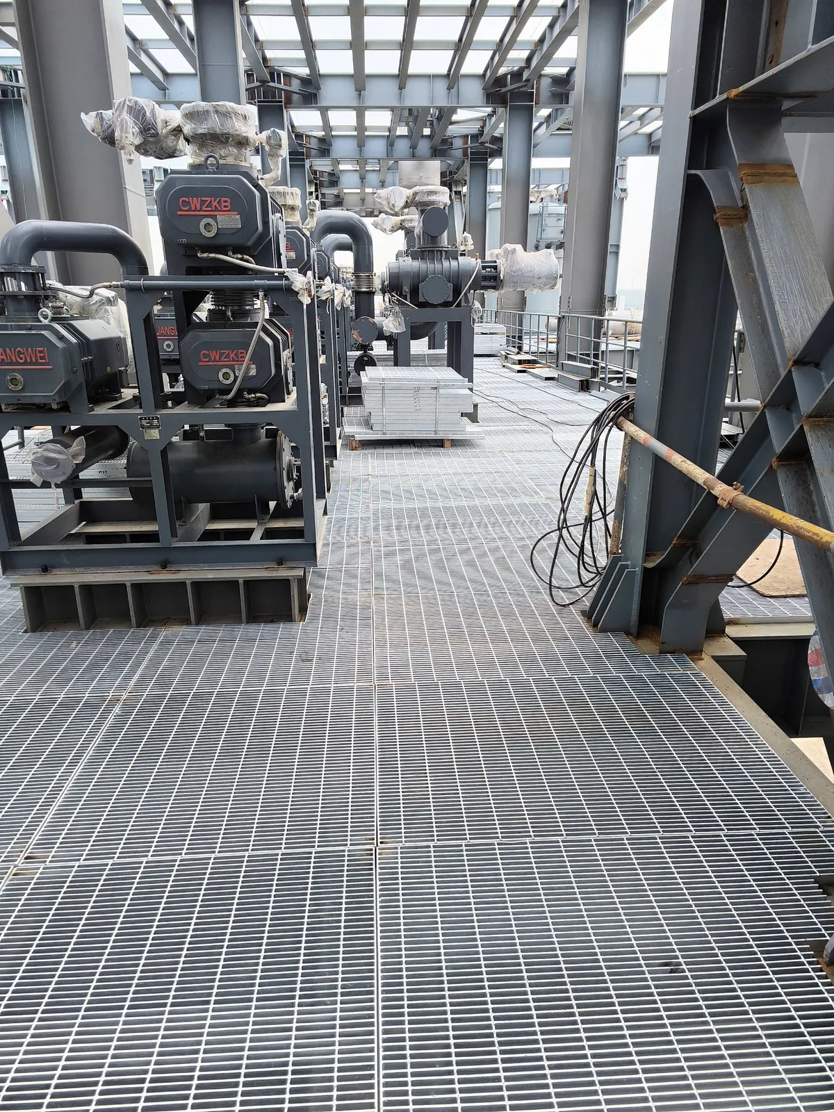 Steel grating maintenance route beside process machinery