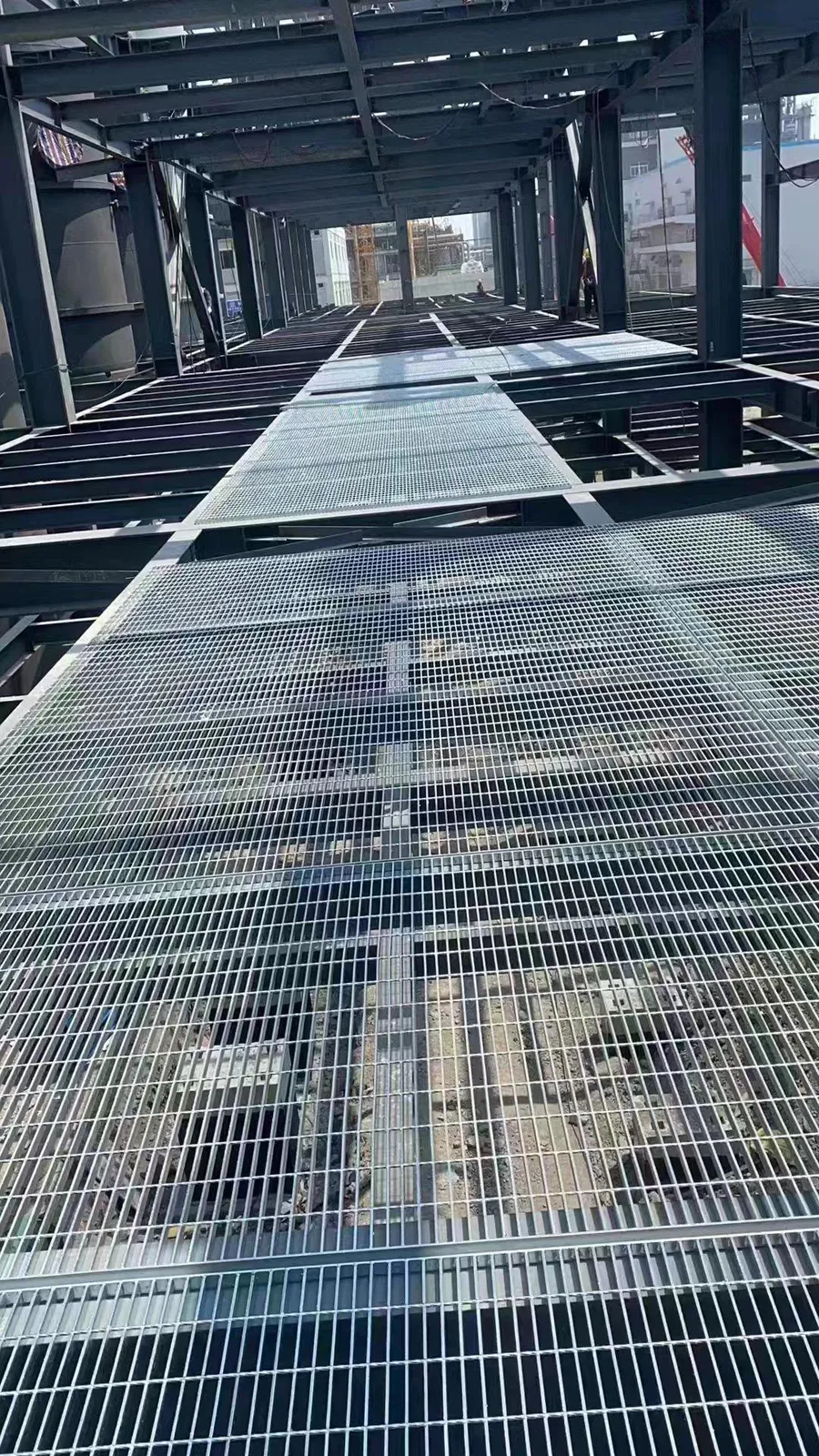 Steel grating installation across a multi-level steel structure