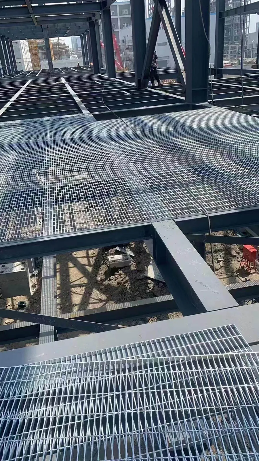 Close view of steel grating fitted around industrial equipment supports