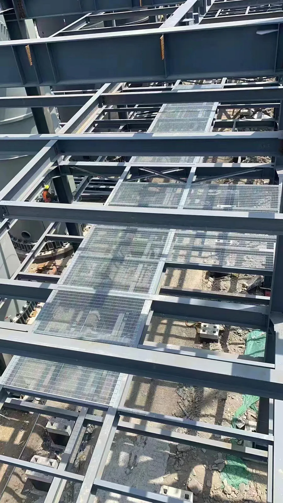 Steel grating flooring under construction across an industrial platform level