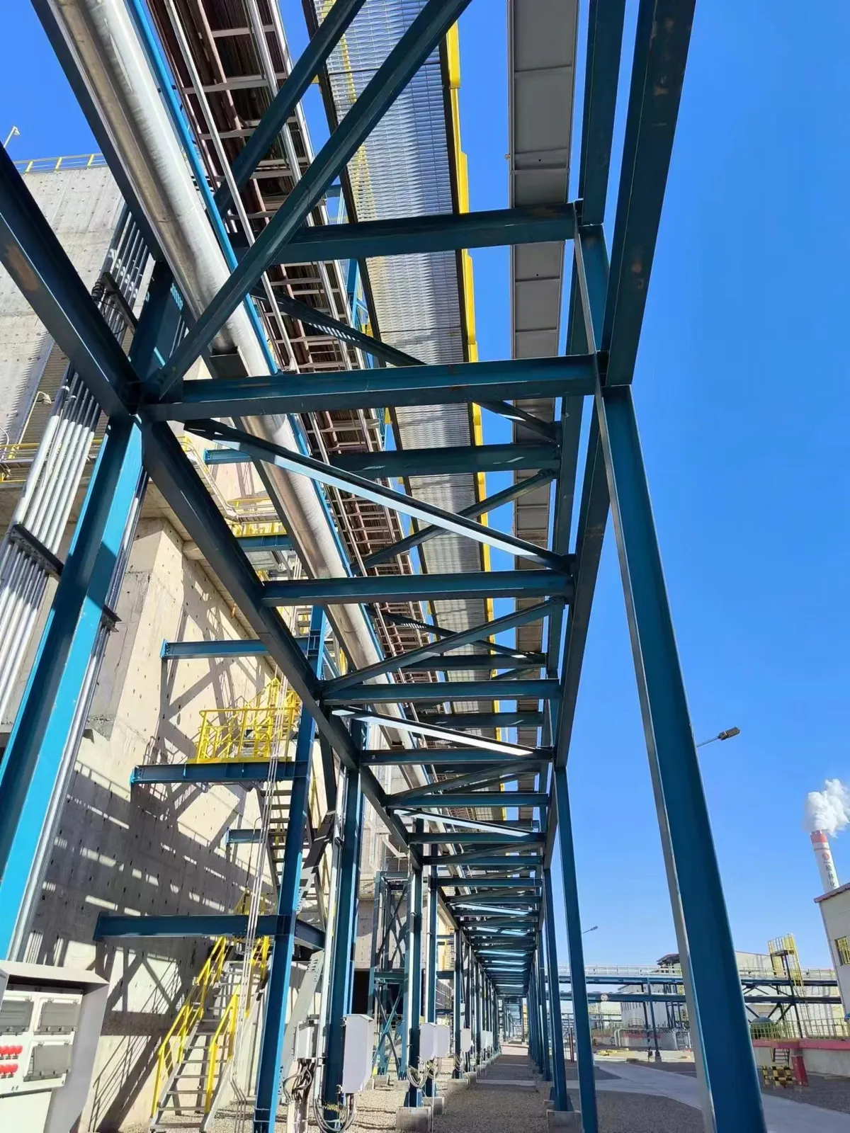 Elevated steel grating maintenance walkway along process piping