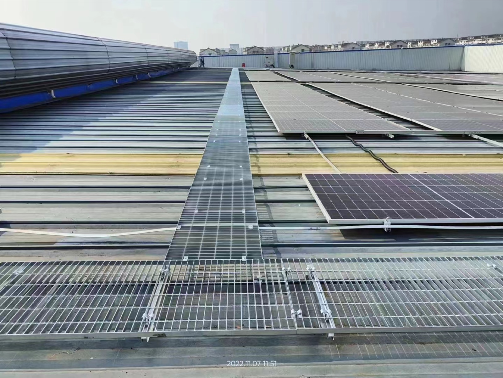 Grating walkway between photovoltaic panel rows
